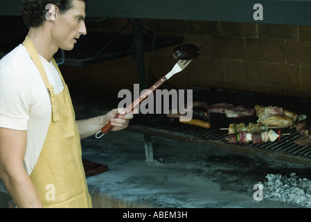 Mann, grillen Fleisch am Grill Stockfoto