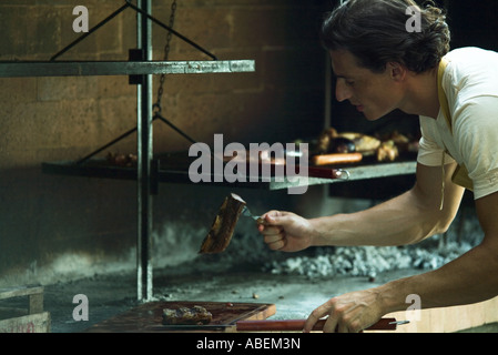 Mann Fleisch am Grill, Grillen, Fleisch auf Holzbrett Stockfoto