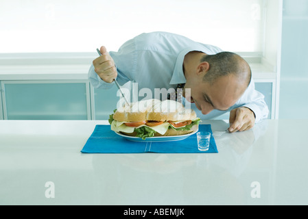 Mann beisst in großen sandwich Stockfoto