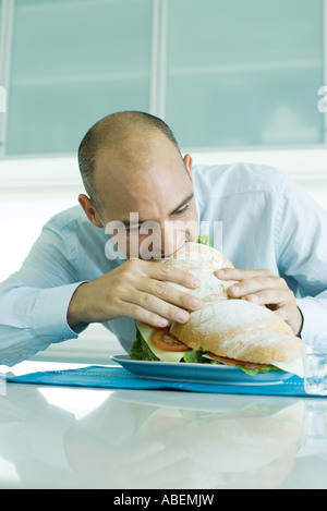 Mann beisst in großen sandwich Stockfoto