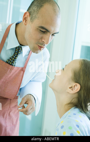 Vater und Tochter teilen Spaghetti Nudel Stockfoto