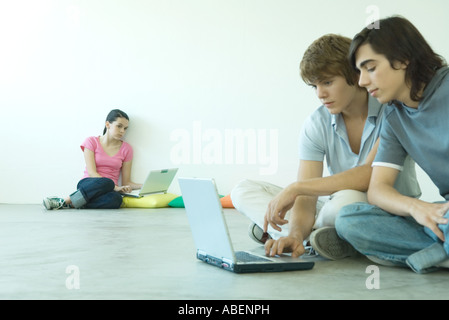 Jugendliche sitzen am Boden, mit Notebooks Stockfoto