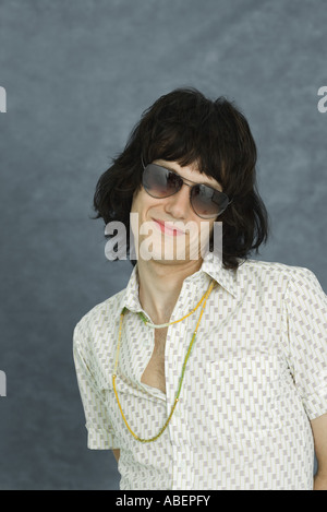 Teenboy tragen Sonnenbrillen und Halskette, lächelnd in die Kamera, Porträt Stockfoto