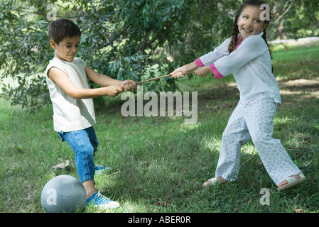 Mädchen und Jungen spielen Tauziehen Stockfoto