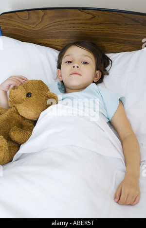 Kind im Bett mit Teddybär Stockfoto