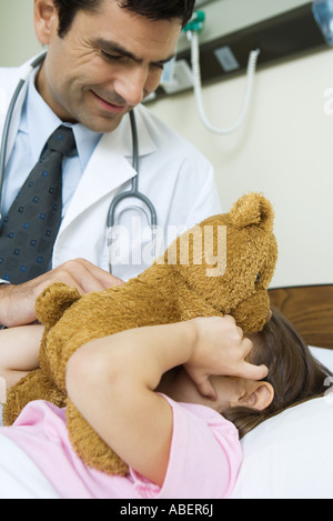 Arzt hält Teddybär bis zum Gesicht des kranken Kindes Stockfoto