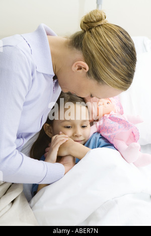 Frau Hand in Hand mit Tochter im Krankenhausbett Stockfoto