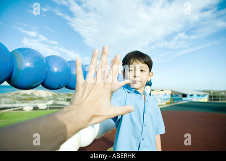 Boy am Spielplatz, Hand zu Hand Erwachsenen durchhalten Stockfoto