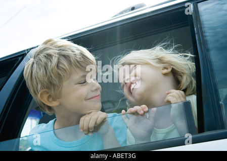 Kinder stecken Köpfe aus Autofenster Stockfoto