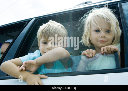 Kinder stecken Köpfe aus Autofenster Stockfoto