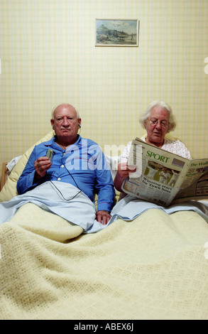 Älteres Paar im Bett, Frau liest Zeitung Stockfoto