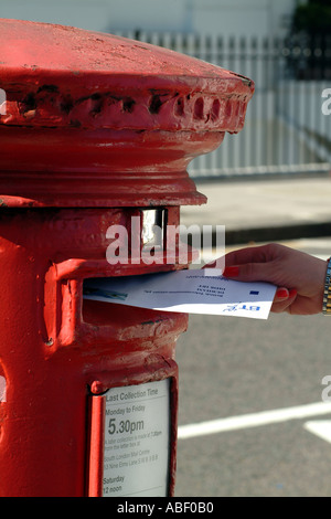 buchen einen Brief in roten Briefkasten London England Vereinigtes Königreich UK Stockfoto