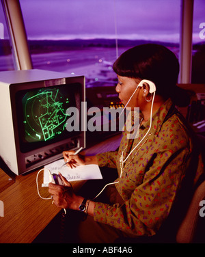 Air Traffic Control - eine Frau Fluglotsen arbeiten in einer Luft Verkehr Kontrollturm ATC auf einem Flughafen in der Dämmerung / USA. Stockfoto