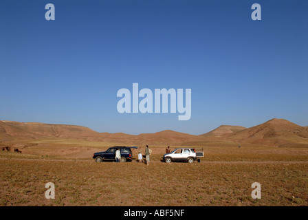 Zwei Fahrzeuge in der Wüste zwischen Marrakesch und den Ausläufern des Atlas, Marokko. Stockfoto