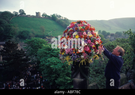 Castleton Garland Day. Eine Blumengirlande auf dem Turm der St. Edmunds Church 29. Mai 1980er Derbyshire Castleton Castle auf einem Hügel. HOMER SYKES Stockfoto