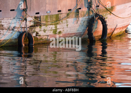 Zwei Reifen hängen von einer alten, rostigen Boot im Hafen in Newport, Rhode Island. Stockfoto