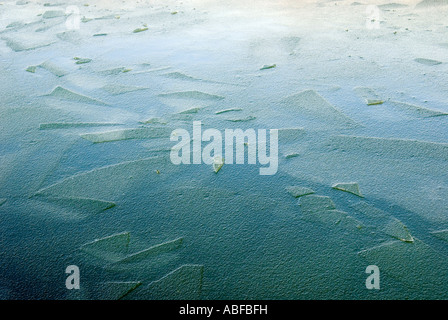 Eisschollen auf einem Kanal in der Nähe von Dudley Port in Großbritannien mit einem blauen Farbton auf dem Wasser gefroren Stockfoto