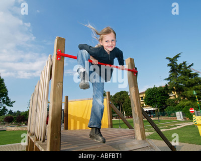 Kleines Mädchen 6 Jahre alt am Klettergerüst lächelnd in die Kamera Peschiera del Garda, Gardasee, Italien. Ihr Name ist Lara Stockfoto