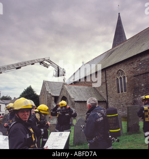 Gruppe von Feuerwehrleuten bekämpfen Dach Brandgefahr durch Kleinkinder an der St. Brannocks Kirche Braunton North Devon in England Stockfoto