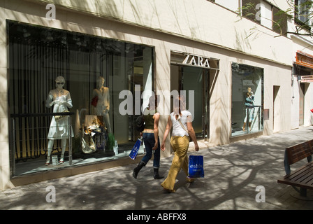 dh Calle de Leon Y Castillo ARRECIFE LANZAROTE zwei junge Damen mit Einkaufen zu Fuß vorbei Zara Bekleidungsgeschäft Mode Mädchen spanien Stoff Geschäft Frauen Stockfoto