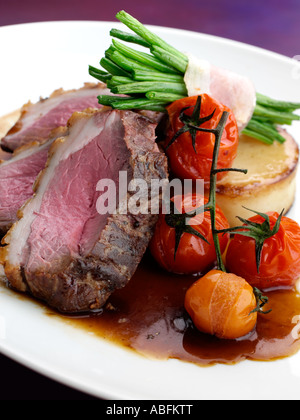 Ein Teller mit Lamm Rump mit Spargel und Wein Tomaten Stockfoto