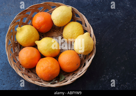 Orangen und Zitronen in einem Weidenkorb Stockfoto