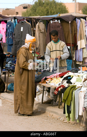 Berber Mann in Mantel und Kopftuch betrachten Kleidung Straßenmarkt Jorf im Tafilalt, Marokko Stockfoto