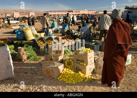 Berber Mann in Mantel und Kapuze sieht über Produkte im freien Wochenmarkt Boumalne du Dades Marokko Stockfoto