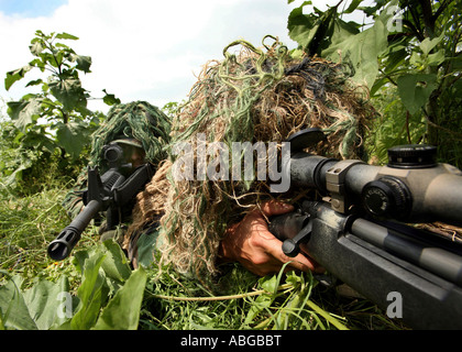 Soldaten in Ghillie-Anzüge gekleidet Zielen auf ein Ziel, während ein Trainingsszenario. Stockfoto