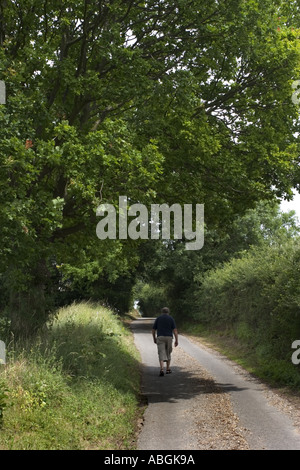 Einem mittleren Alter Mann schlendert nach unten einen schmalen Feldweg in England UK Stockfoto