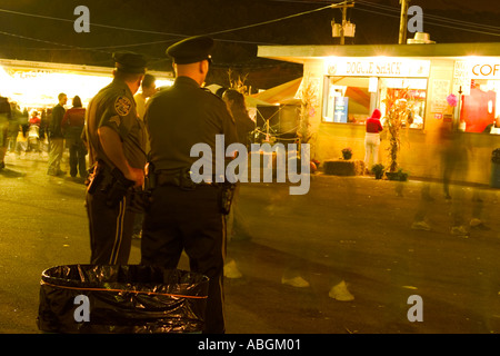 Polizisten auf einer Messe in der Nacht ein Auge auf die Dinge Stockfoto