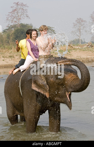 Elefanten splash und spielen überraschendste junge Touristen im Fluss auf Wanderung in der Nähe von Pai Nord Thailand Stockfoto