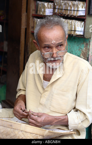 Indischer Mann macht Beadies (handgemachte Zigaretten) in eine kleine Gasse-Shop, Varanasi, Indien Stockfoto