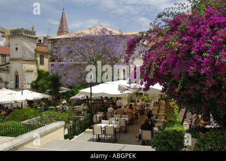 Altstadt von Korfu urlaub insel Jacaranda Tree & Bougainvillea mit Diners unter Sonnenschirm Schatten im Garten eines Restaurants Taverna business Griechenland Stockfoto