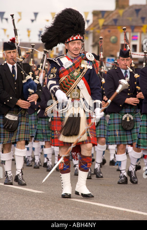 Schottische Volksmusik Pipe major mit Dudelsackkapelle marschieren hinunter Annan High Street Scotland UK Stockfoto