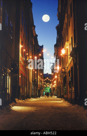 Vollmond über Schnee und Lamplights am ältesten mit Weihnachtsschmuck in Stockholms Altstadt Stockfoto