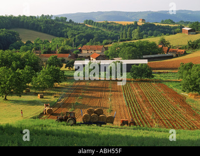 Traktoren sammeln Heu auf Bauernhof in Dordogne Frankreich gerollt Stockfoto