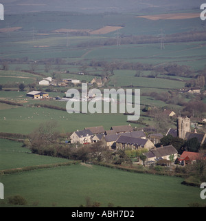 Blick hinunter auf, kleines Dorf mit Kirche und alte und neue Gehäuse eingestellt in Ackerland in der Nähe von Dorchester, Dorset Stockfoto