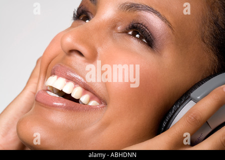 Porträt einer jungen Frau lächelnd, Musikhören mit Kopfhörer Stockfoto