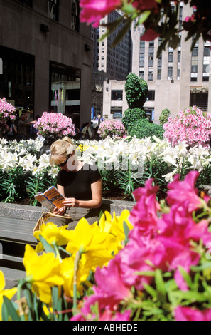 FRAU LESEN STADTFÜHRER AM ROCKEFELLER CENTER NEW YORK. MODEL RELEASE VERFÜGBAR AUF ANFRAGE. Stockfoto