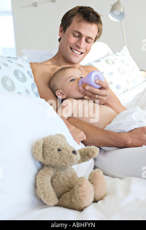 Vater sein Baby drinnen Fütterung Stockfoto