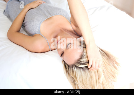 Junge Frau auf Bett, Ansicht von oben, innen Stockfoto