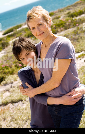 Ältere Frau und Erwachsene Tochter, umarmen, draußen Stockfoto