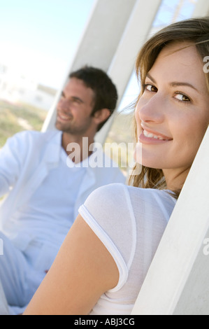 Paar auf Terrasse, Frau Lächeln für die Kamera im Vordergrund Stockfoto