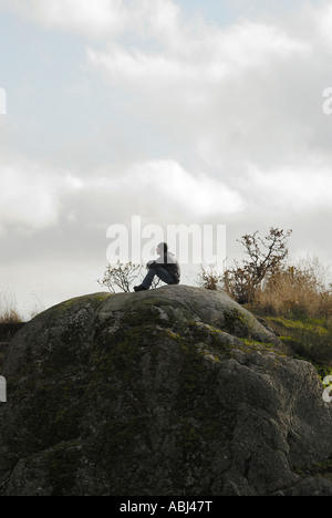 Mann sitzt auf einem Felsen in Victoria, Stadt von Vancouver Island Stockfoto