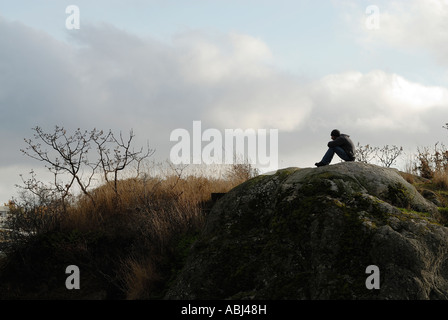 Mann sitzt auf einem Felsen in Victoria, Stadt von Vancouver Island Stockfoto