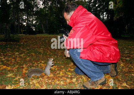 Mann trägt einen roten Mantel suchen ein Eichhörnchen Stockfoto