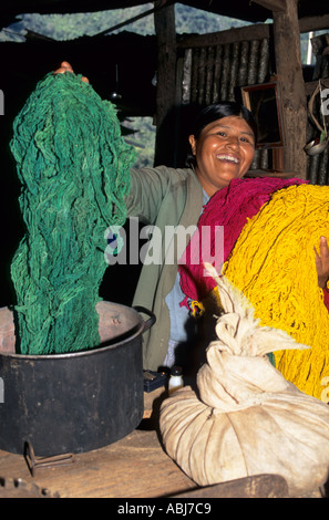 Urubamba-Tal, Peru. Lächelnde Quechua-Frau zeigt ihre frisch gefärbte Wolle Stränge. Stockfoto