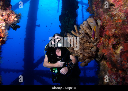 Taucher schwimmen durch eine Bohrinsel im Golf von Mexiko aus Texas Stockfoto