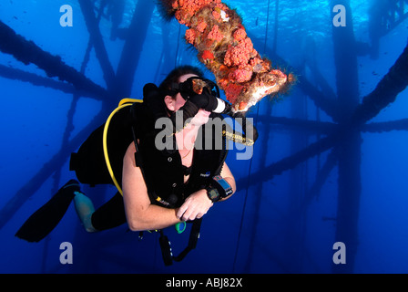 Taucher schwimmen durch eine Bohrinsel im Golf von Mexiko aus Texas Stockfoto